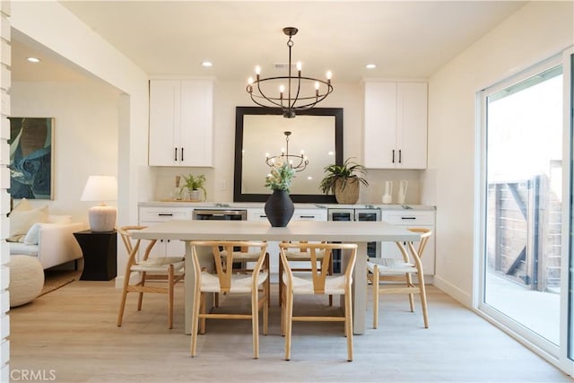 dining area with a chandelier, recessed lighting, and light wood-style floors