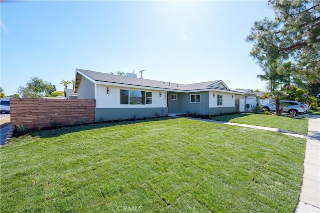 ranch-style house with a front lawn, fence, and stucco siding