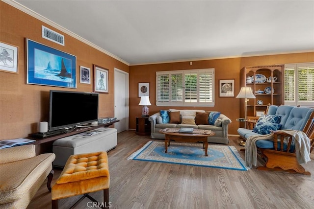 living area featuring ornamental molding, visible vents, and wood finished floors