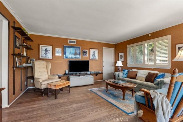 living area featuring visible vents, ornamental molding, and wood finished floors