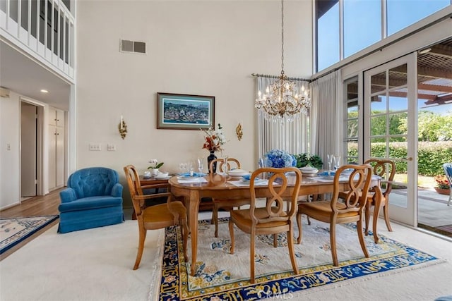 dining room with a high ceiling, visible vents, and an inviting chandelier