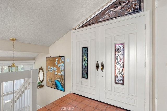 foyer entrance featuring lofted ceiling with beams, a textured ceiling, and tile patterned floors