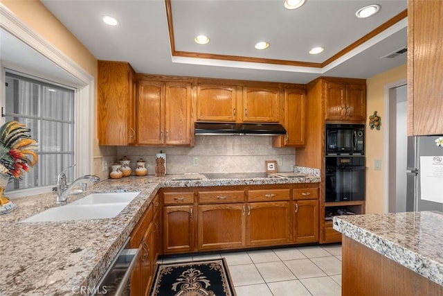 kitchen featuring under cabinet range hood, a sink, backsplash, black appliances, and a raised ceiling