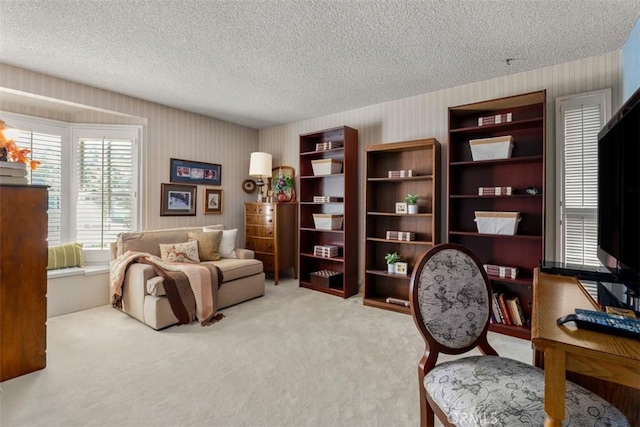 sitting room featuring light carpet, a textured ceiling, and wallpapered walls