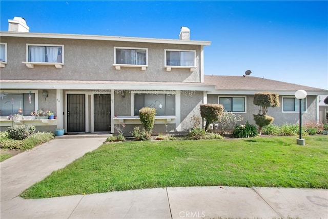 2061 W Redlands Blvd Unit 8C, Redlands, CA 92373 - view of front of home with stucco siding, a front yard, and a chimney
