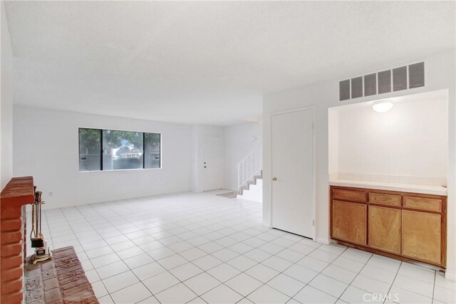 2061 W Redlands Blvd Unit 8C, Redlands, CA 92373 - unfurnished living room with stairway and light tile patterned floors