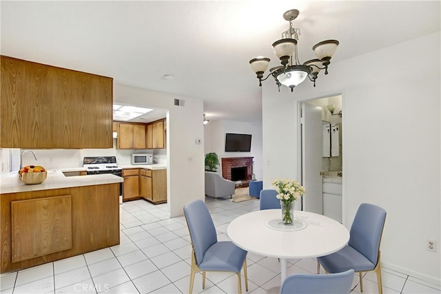2061 W Redlands Blvd Unit 8C, Redlands, CA 92373 - dining space featuring a chandelier, a brick fireplace, and light tile patterned floors
