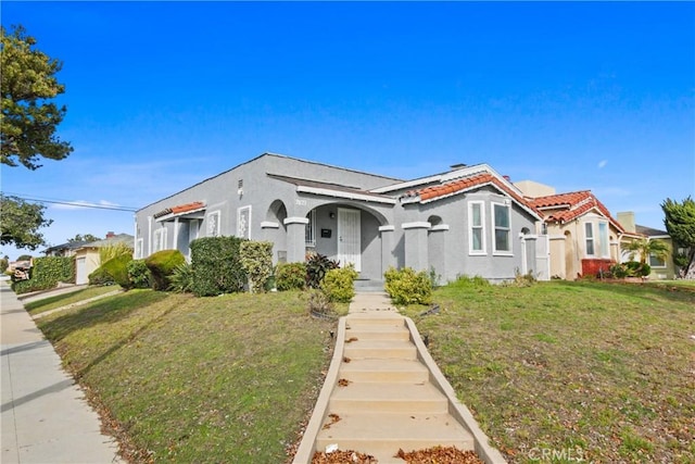 mediterranean / spanish-style home with a front lawn and stucco siding