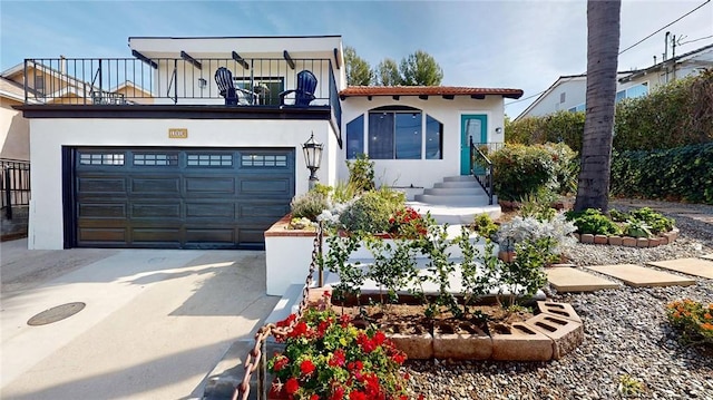 view of front of house featuring driveway, a balcony, and stucco siding