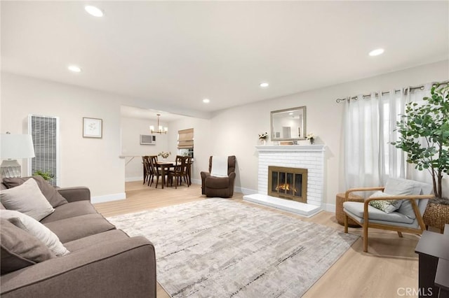 living area with a fireplace, baseboards, recessed lighting, and light wood-style flooring