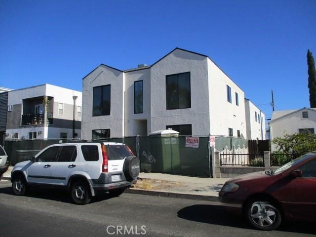 view of front of house with fence and stucco siding