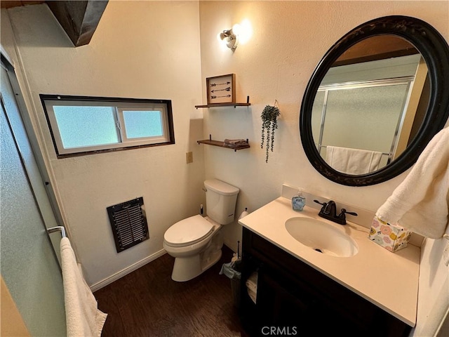 bathroom featuring an enclosed shower, vanity, toilet, and wood finished floors