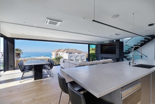 kitchen featuring sink, a center island, a healthy amount of sunlight, and light hardwood / wood-style flooring