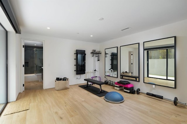 workout area with light hardwood / wood-style flooring