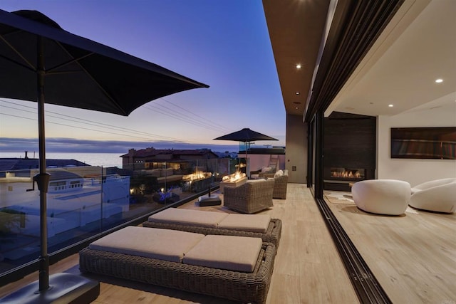 patio terrace at dusk featuring an outdoor living space with a fireplace