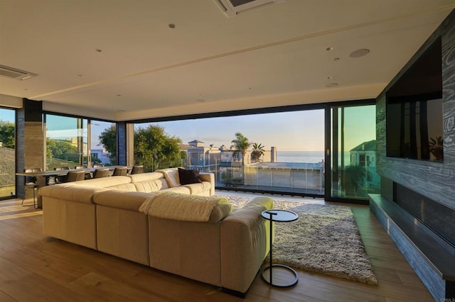 living room featuring hardwood / wood-style floors, a wall of windows, and plenty of natural light