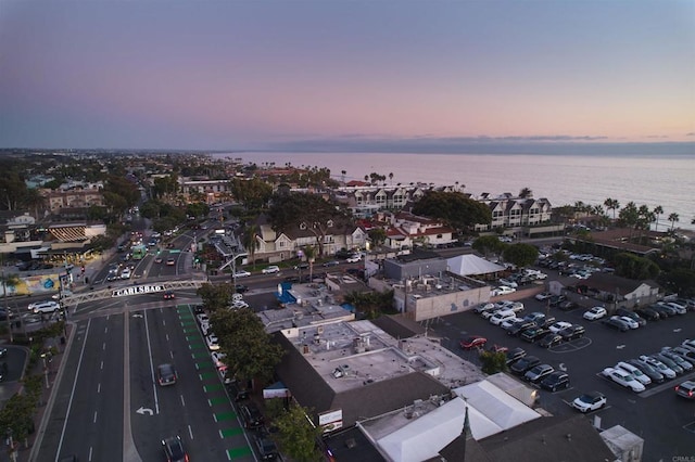 aerial view at dusk featuring a water view