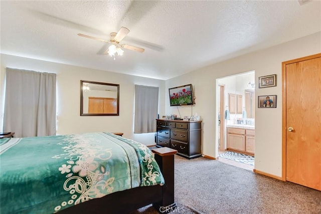 carpeted bedroom featuring ensuite bath, a textured ceiling, baseboards, and ceiling fan