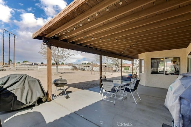 view of patio featuring outdoor dining area, a grill, and fence