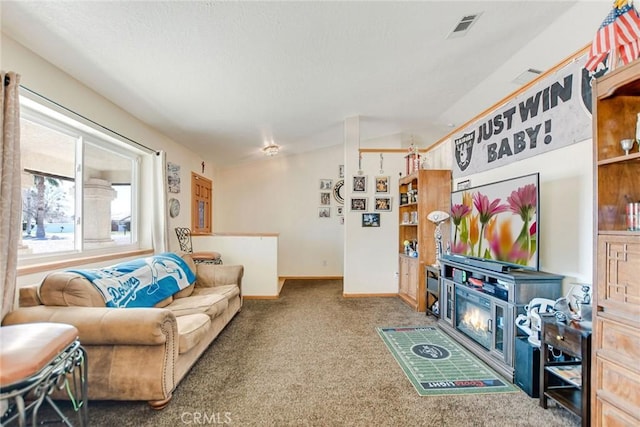 carpeted living area with lofted ceiling, visible vents, and baseboards