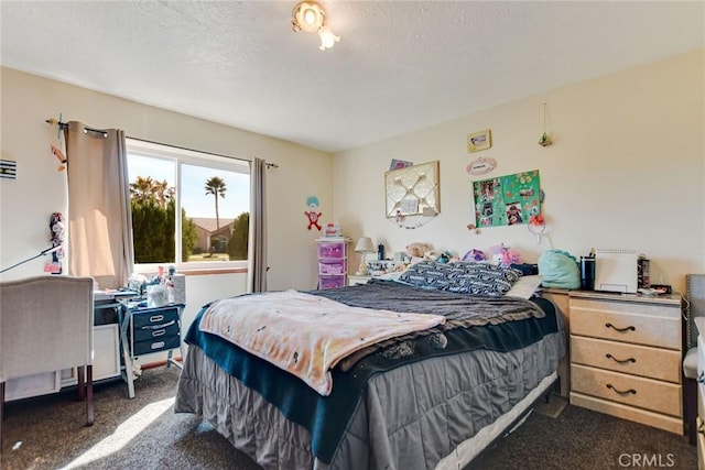 bedroom with dark carpet and a textured ceiling