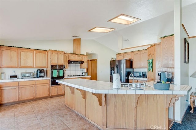 kitchen with tile countertops, stainless steel fridge with ice dispenser, light brown cabinets, a peninsula, and a kitchen breakfast bar