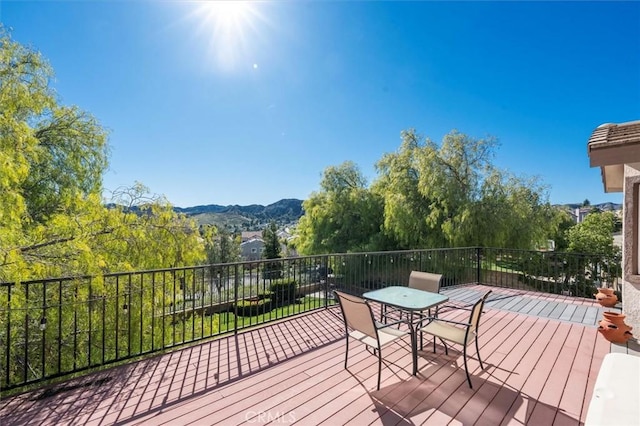 deck featuring outdoor dining space and a mountain view