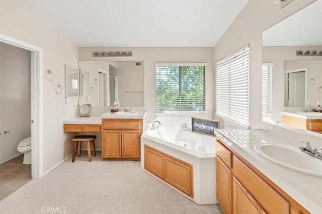 bathroom featuring a garden tub, lofted ceiling, visible vents, toilet, and vanity