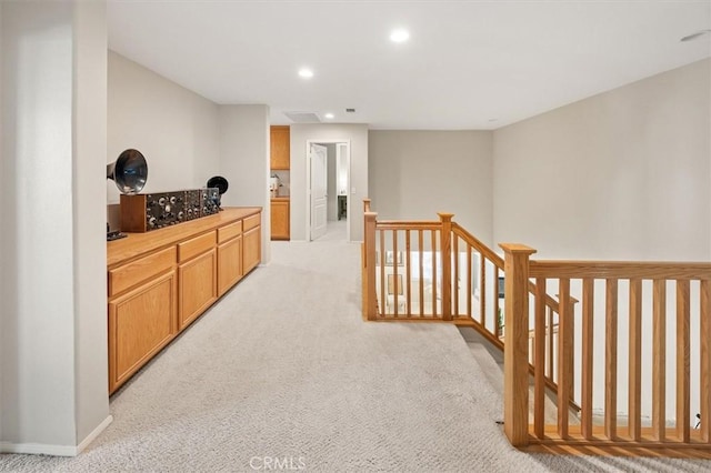 corridor featuring baseboards, recessed lighting, an upstairs landing, and light colored carpet