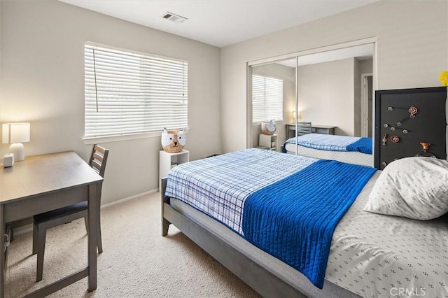 carpeted bedroom featuring a closet, visible vents, and baseboards