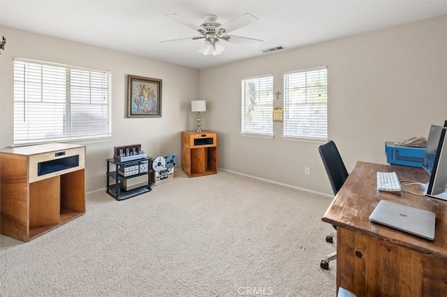 home office featuring ceiling fan, visible vents, baseboards, and light colored carpet