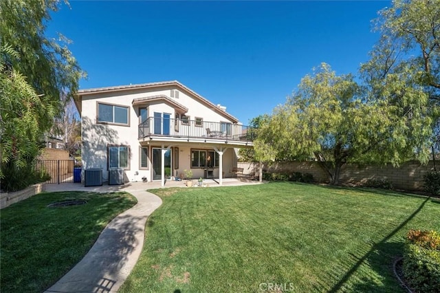 rear view of property featuring a patio area, a fenced backyard, a yard, and a balcony