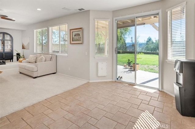 doorway to outside with baseboards, light colored carpet, visible vents, and a healthy amount of sunlight