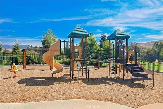 community play area featuring fence and a mountain view