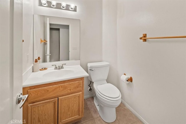 bathroom featuring tile patterned flooring, baseboards, vanity, and toilet