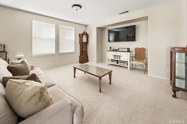 carpeted living area featuring visible vents and baseboards