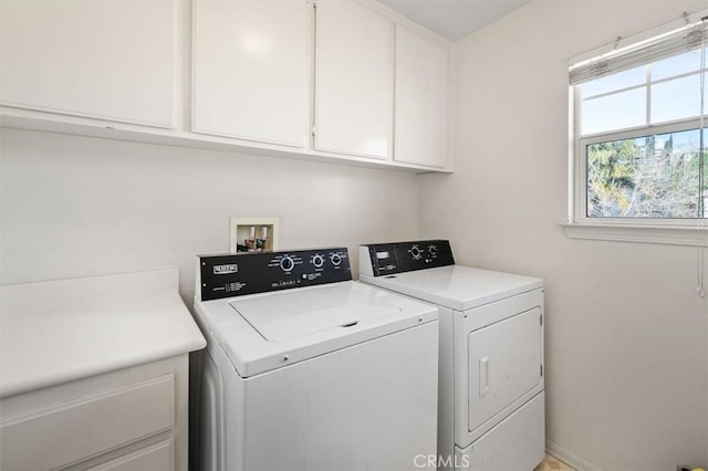 washroom featuring cabinet space, washer and clothes dryer, and baseboards