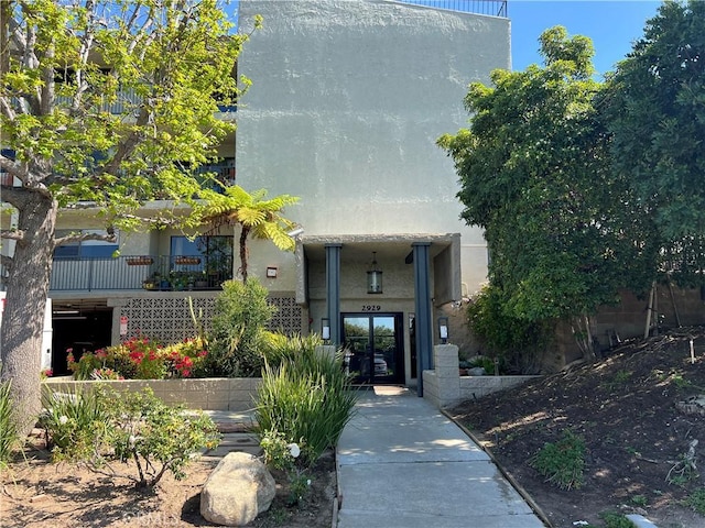 view of exterior entry with stucco siding and french doors