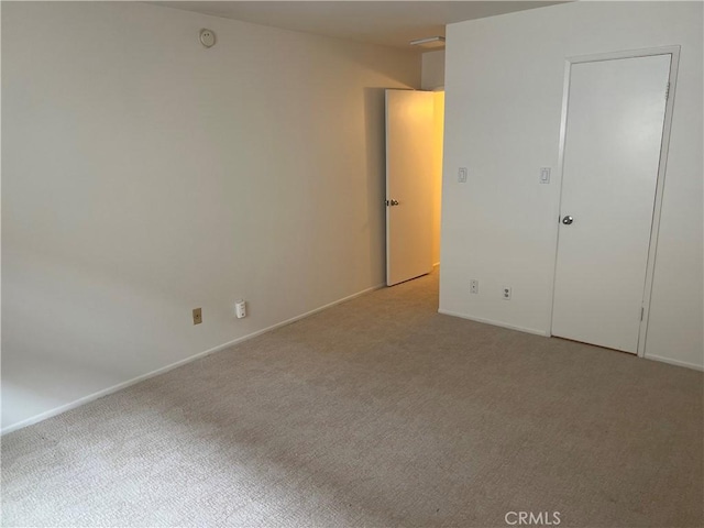 carpeted empty room with baseboards