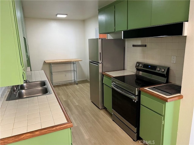 kitchen featuring green cabinetry, tile countertops, and appliances with stainless steel finishes