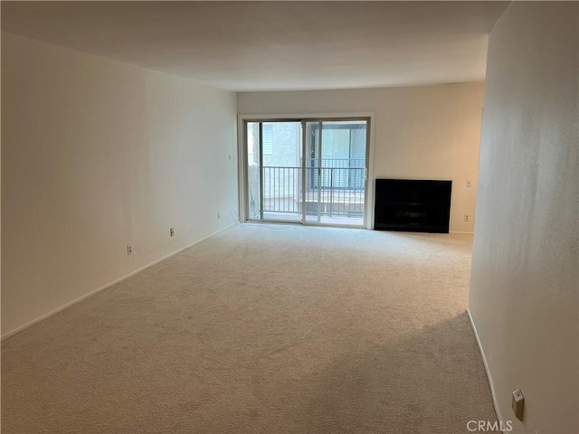 unfurnished room with baseboards, carpet floors, and a fireplace