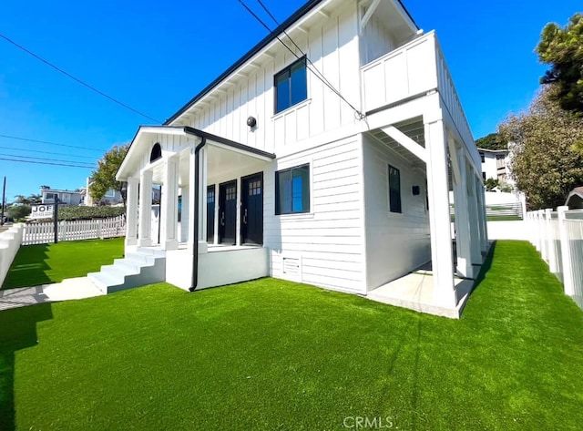 rear view of house featuring a yard