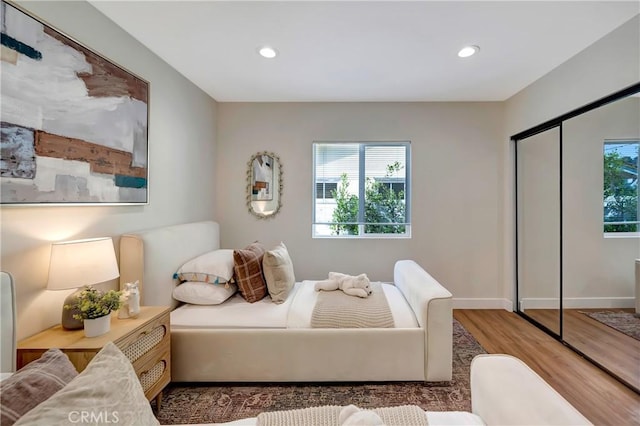 bedroom with recessed lighting, multiple windows, and wood finished floors