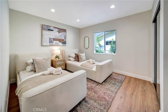 bedroom with light wood-type flooring, baseboards, and recessed lighting