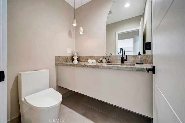 half bathroom with recessed lighting, vanity, and toilet