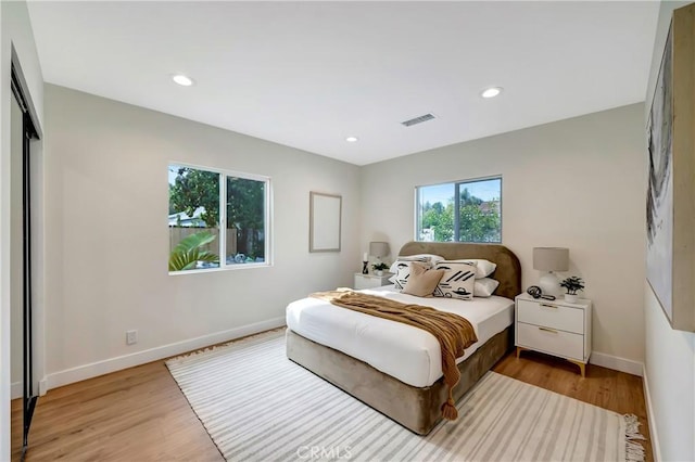 bedroom with light wood-style flooring, visible vents, baseboards, and recessed lighting