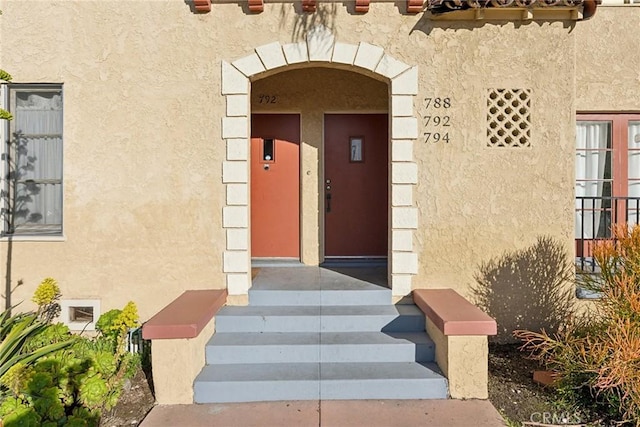 entrance to property featuring stucco siding