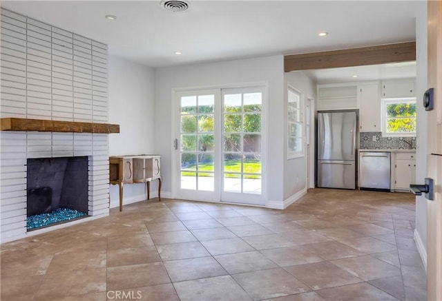 unfurnished living room with light tile patterned flooring and a fireplace