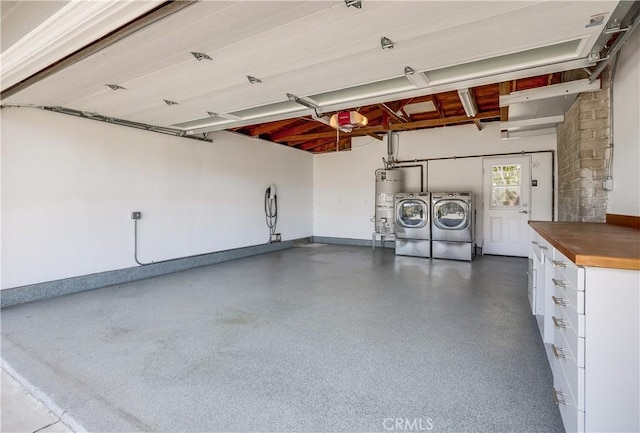 garage featuring washer and clothes dryer, gas water heater, and a garage door opener