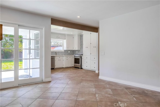 kitchen featuring decorative backsplash, light tile patterned flooring, stainless steel appliances, and white cabinets